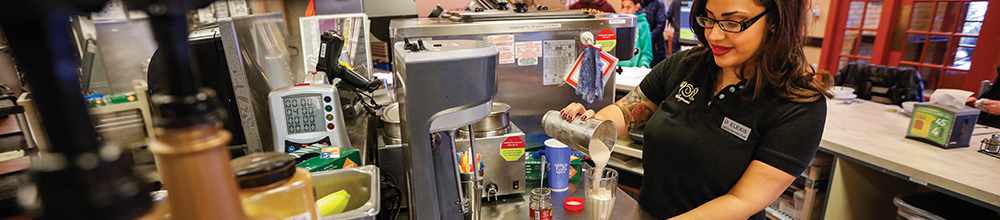 Woman making a milkshake at the Burger Bar by Wegmans